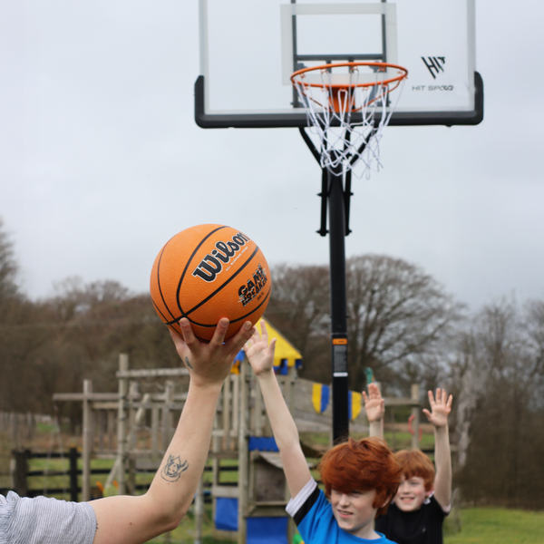 Kids playing Basketball infront of the Hit Sport 10ft Premium Adjustable Basketball Hoop Series 3