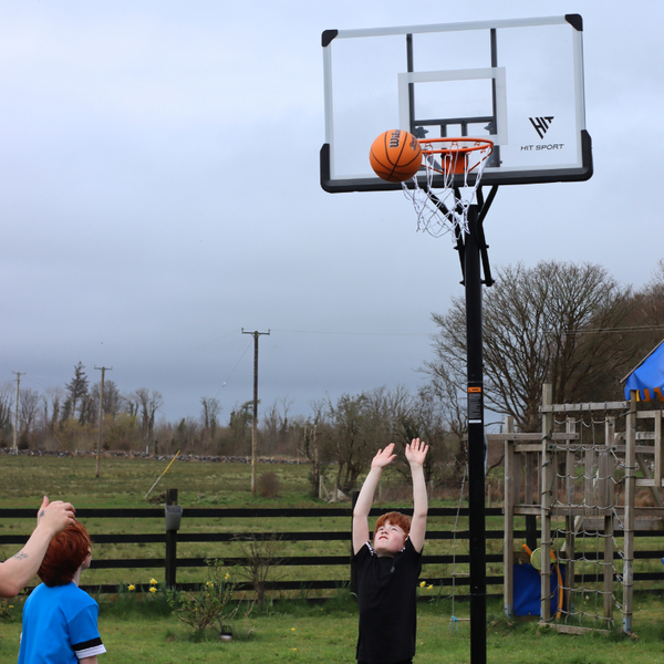 A Kid catching a Basketball infront of the Hit Sport 10ft Premium Adjustable Basketball Hoop Series 3