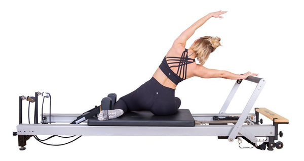Woman doing stretches on a Align Pilates C8-Pro Studio Pilates Reformer