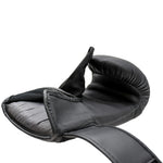 Close-up side view of a black Urban Fight punch bag mitt lying flat with the palm side and thumb visible, showing padding and open velcro strap, on a white background.