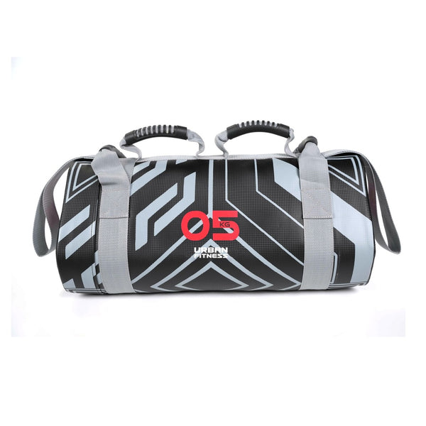 Urban Fitness Power Bag 5kg with ergonomic handles and straps, set against a plain gym wall background.