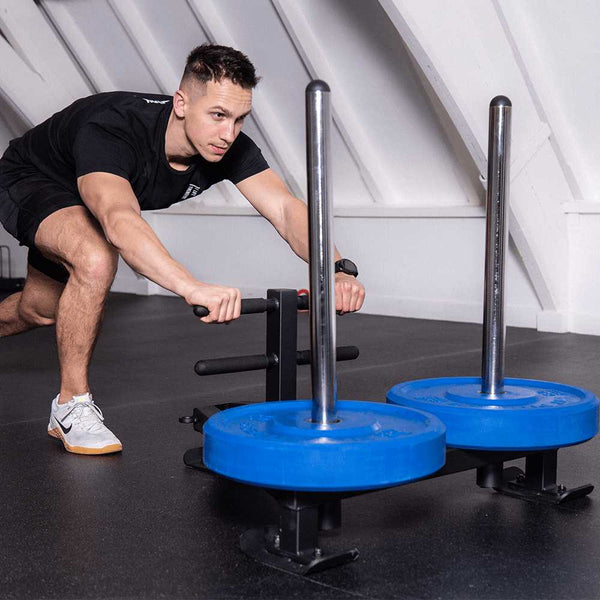 Man trains his upper body by pushing the HIT FITNESS Deluxe Power Sled With Harness.