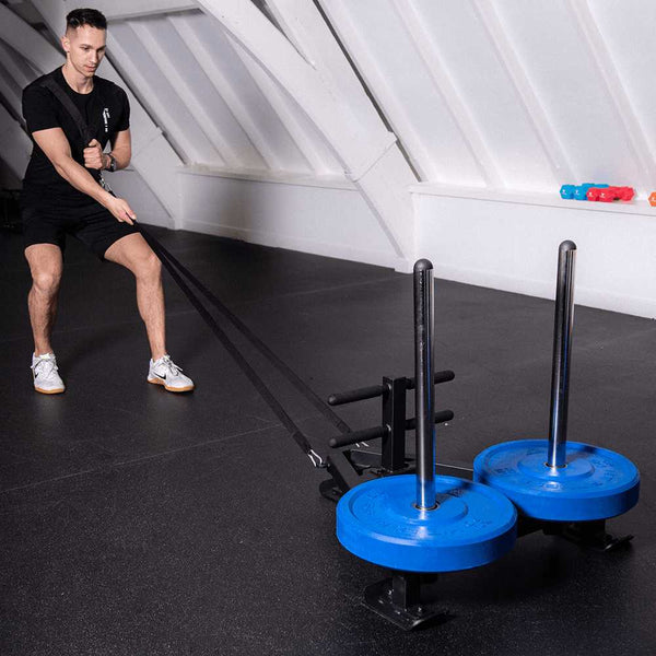 Man trains his body strength by pulling the HIT FITNESS Deluxe Power Sled With Harness.