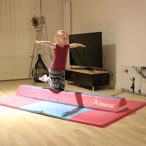 Girl kneeling on a Balance Beam