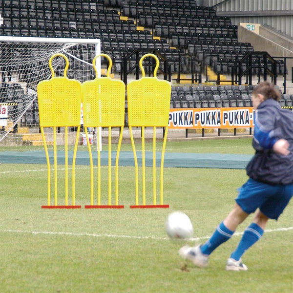 Soccer Player practicing a free kick with Manequins